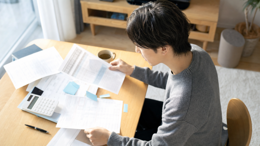 明るい部屋で賃貸の見積書を比較する人
